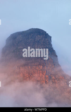 Die schroffen Klippen der Stac Pollidh in Wolken und Nebel und Abendlicht beleuchtet. Cairngorm National Park, Schottland, Juli. Stockfoto