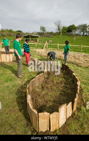 Die jungen Freiwilligen Hilfe angesprochen, die Betten für den Anbau von Lebensmitteln, auf die Erde Umweltprojekt, Murton, Gower, South Wales, UK 2009 erstellen Stockfoto