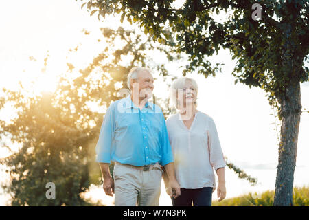 Ältere Frau und Mann mit einem Spaziergang entlang Pfad in der Landschaft Stockfoto