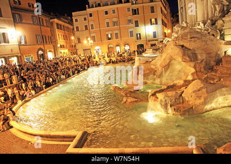 Menschenmengen sammeln sich um den Trevi-Brunnen (Fontana di Trevi) in der Nacht in Rom Stockfoto