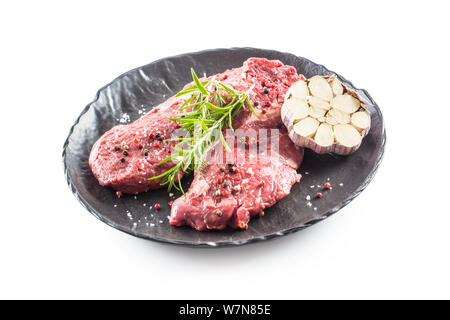 Rindfleisch meeat Rib-Eye steak wit Rosmarin Salz und Pfeffer schwarz Platte isoliert auf weißem Stockfoto