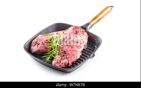 Rindfleisch meeat Rib-Eye steak wit Rosmarin Salz und Pfeffer in der Grillpfanne auf Weiß isoliert Stockfoto