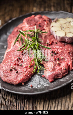 Rindfleisch meeat Rib-Eye steak wit Rosmarin Salz und Pfeffer auf schwarze Platte Stockfoto