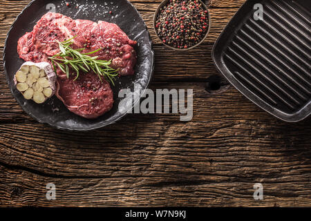 Rindfleisch meeat Rib-Eye steak wit Rosmarin Salz und Pfeffer auf schwarze Platte Stockfoto