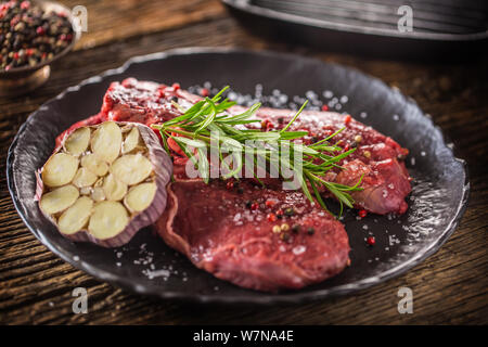 Rindfleisch meeat Rib-Eye steak wit Rosmarin Salz und Pfeffer auf schwarze Platte Stockfoto