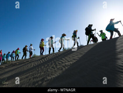 Chinesische Enthusiasten zu Fuß in den nationalen Desert Sports Park während einer 10-Kilometer Wüste wandern Herausforderung Wettbewerb in Zhangye Stadt im Nordwesten Chinas G Stockfoto