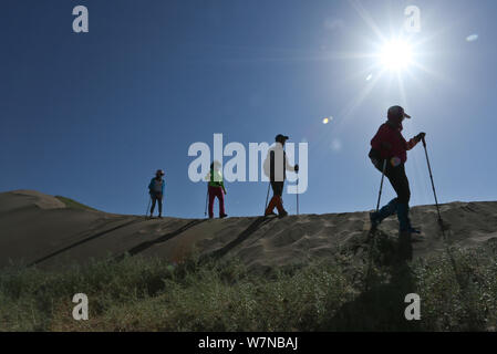 Chinesische Enthusiasten zu Fuß in den nationalen Desert Sports Park während einer 10-Kilometer Wüste wandern Herausforderung Wettbewerb in Zhangye Stadt im Nordwesten Chinas G Stockfoto