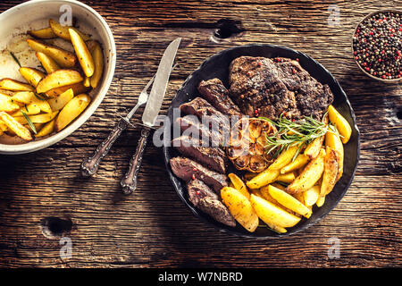 Gegrilltes Rindfleisch Rib Eye Steak mit Knoblauch amerikanische Kartoffeln Rosmarin Salz und Gewürze Stockfoto