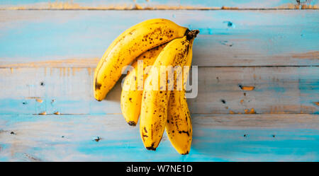 Gelbe Bananen auf einem blauen Holztisch Hintergrund - Konzept der Kalium- und gesunden Lebensstil mit Früchten der Saison - Vitamine und vegetarische oder vegane l Stockfoto