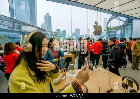 ------ Chinesische Kunden versuchen, Beats Kopfhörer und iphones an einem neu - Apple Store in der Stadt Guangzhou, Provinz Guangdong, Südchina, 29 J Stockfoto