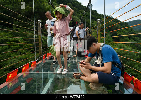 Touristen zu Fuß auf den Berg - Kreuzung suspension Brücke aus Glas bei Mulan Tianchi scenic Spot in Wuhan City, Central China Provinz Hubei, 18. Juni 201 Stockfoto