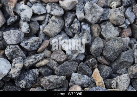 Kies Stein -Textur. Stein und Kies auf dem Boden zerquetscht. Textur Hintergrund braun Steine auf einem schwarzen Erde Hintergrund. Bild der gebrochene Steine und g Stockfoto