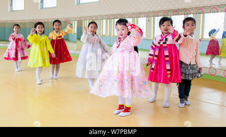 Kinder in traditioneller Kleidung, winken in die Kamera, Mangyongdae Schulkinder's Palace, gewidmet der Kinder nach der Schule Aktivitäten, Pjöngjang, der Demokratischen Volksrepublik Korea (DVRK), Nordkorea, 2012 Stockfoto