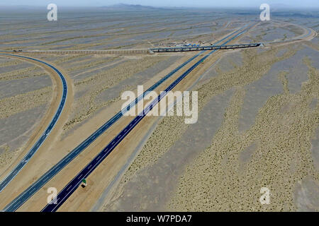 Luftaufnahme des Beijing-Urumqi Schnellstraße quer durch die Wüste Gobi mit einer Gesamtlänge von 2.450 Kilometern in Hami Stadt im Nordwesten Chinas Stockfoto