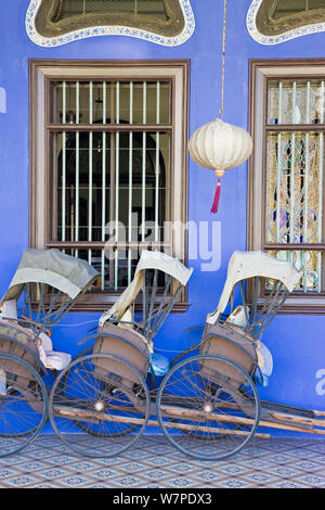 Detail der Trishaws aufgereiht vor einem blauen bemalte Mauer in Chinatown, Georgetown, Penang (Pulau Pipang) Malaysia 2008 Stockfoto