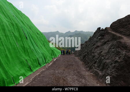 Blick auf die Ausgrabungsstätte von dinosaurierfossilien in einer Wand 150 Meter lang, 2 Meter tief und 8 Meter hoch, im Dorf Laojun, Pu'eine Stadt konzentriert Stockfoto