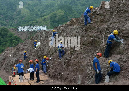 Chinesische Arbeiter auszugraben Dinosaurier Fossilien in einer Wand 150 Meter lang, 2 Meter tief und 8 Meter hoch, an der Ausgrabungsstätte in Laojun vi konzentriert Stockfoto