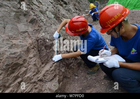 Chinesische Arbeiter auszugraben Dinosaurier Fossilien in einer Wand 150 Meter lang, 2 Meter tief und 8 Meter hoch, an der Ausgrabungsstätte in Laojun vi konzentriert Stockfoto