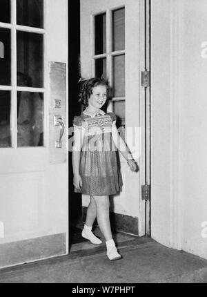 Vintage Foto der amerikanischen Kind Film star Shirley Temple (1928-2014). Das Bild wurde am 24. Juni 1938 gefangen, während die junge Schauspielerin das Weiße Haus links nach einem Treffen mit US-Präsident Franklin D Roosevelt. Während Ihrer Konversation Sie erklärte der Präsident, wie sie verloren hatte einen Zahn in der Nacht vor, wenn es fiel aus, als sie ein Sandwich gegessen. Stockfoto