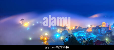 Die Stadt in der Nacht Nebel mit hellem elektrischem Licht im Nebel erzeugen eine phantasievolle, beeindruckende Szene in Da Lat, Vietnam gesunken Stockfoto