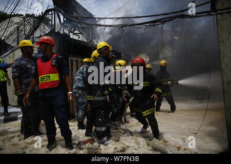 Kathmandu, Nepal. 7 Aug, 2019. Feuerwehrmänner und Sicherheitspersonal aus Nepal Polizei, bewaffnete Polizei in Nepal und Nepal Armee begießen, das Feuer im Gebäude des Subisu, einem Internet Service Provider am Baluwatar in Kathmandu, Nepal am Mittwoch, August 07, 2019 gefangen. Credit: Skanda Gautam/ZUMA Draht/Alamy leben Nachrichten Stockfoto