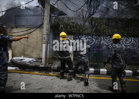 Kathmandu, Nepal. 7 Aug, 2019. Feuerwehrmänner und Sicherheitspersonal aus Nepal Polizei, bewaffnete Polizei in Nepal und Nepal Armee begießen, das Feuer im Gebäude des Subisu, einem Internet Service Provider am Baluwatar in Kathmandu, Nepal am Mittwoch, August 07, 2019 gefangen. Credit: Skanda Gautam/ZUMA Draht/Alamy leben Nachrichten Stockfoto