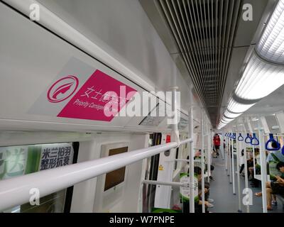 Passagiere, die in einer U-Bahn mit "Priorität Kutschen für Frauen" auf der U-Bahn-Linie 1 in Shenzhen City, South China Guangdong provi Stockfoto