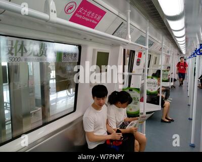 Passagiere, die in einer U-Bahn mit "Priorität Kutschen für Frauen" auf der U-Bahn-Linie 1 in Shenzhen City, South China Guangdong provi Stockfoto