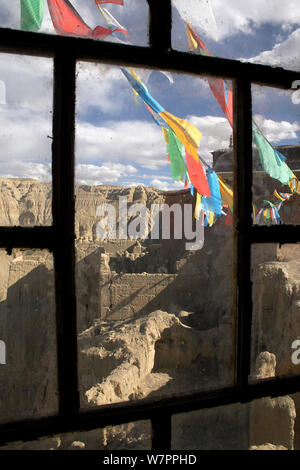 Buddhistische Gebetsfahnen außerhalb Fenster Rahmen in Tsaparang (manchmal als das mythische Shangri-la bekannt) war die Hauptstadt des alten Königreichs Guge in der Garuda Tal, Präfektur Ngari, Western Tibet. Tsaparang ist eine riesige Festung auf einer Pyramide thront - geformten Felsen steigt über 600 Fuß (183 m). Es enthält zahlreiche Tunnel und Höhlen, die aus dem Fels gehauen wurden. Stockfoto