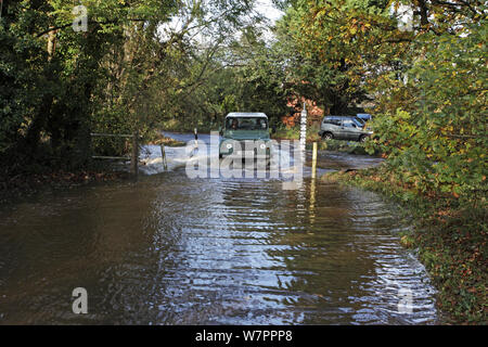 Landrover fahren durch die überschwemmten Ford über die Lin-Bach Bach, in der Nähe von Ringwood, Hampshire, England, Großbritannien, November 2012 Stockfoto