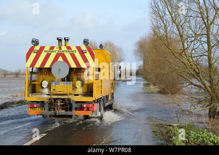 Autobahn Wartung während der Fahrt durch Überschwemmungen auf stark überflutet A361 zwischen East Lyng und Burrowbridge über Unteren Salz Moor nach Wochen der schwere Regen, Somerset, UK, Januar 2013. Stockfoto