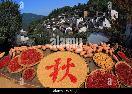 Jiangxi, Jiangxi, China. 7 Aug, 2019. Jiangxi, China - Am 7. August 2019, dem Beginn der Herbst begann, und die Ernten der Huangling altes Dorf in Wuyuan County, Provinz Jiangxi waren im Allgemeinen geerntet und das trockene Korn Jahreszeit angekommen. Die Dorfbewohner von huangling Ernten bunten Pflanzen, wie Paprika, Mais und Kürbis, und Sie auf dem Holz Wäscheständer vor und hinter Hui hang-Stil folk Häuser entlang der Berg, der strahlend in der Sonne werden gebaut, und die Szene ist ziemlich spektakulär. Credit: SIPA Asien/ZUMA Draht/Alamy leben Nachrichten Stockfoto