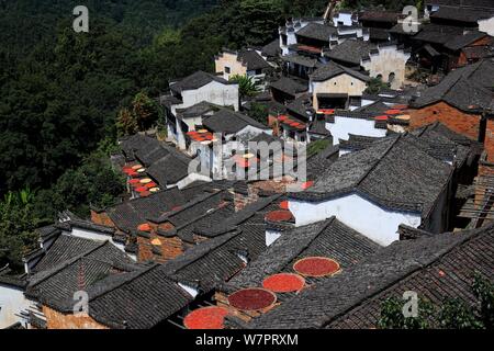 Jiangxi, Jiangxi, China. 7 Aug, 2019. Jiangxi, China - Am 7. August 2019, dem Beginn der Herbst begann, und die Ernten der Huangling altes Dorf in Wuyuan County, Provinz Jiangxi waren im Allgemeinen geerntet und das trockene Korn Jahreszeit angekommen. Die Dorfbewohner von huangling Ernten bunten Pflanzen, wie Paprika, Mais und Kürbis, und Sie auf dem Holz Wäscheständer vor und hinter Hui hang-Stil folk Häuser entlang der Berg, der strahlend in der Sonne werden gebaut, und die Szene ist ziemlich spektakulär. Credit: SIPA Asien/ZUMA Draht/Alamy leben Nachrichten Stockfoto