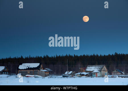 Vollmond über dem Dorf, Arctic Circle Dive Center, Weißes Meer, Karelien, nördlichen Russland März 2010 Stockfoto