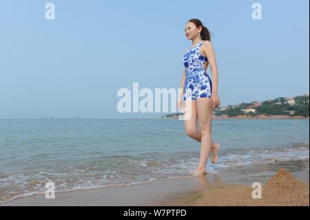 Ein Modell trägt einen Badeanzug mit blau-weißem Porzellan und Stickerei dargestellt an einem Beach Resort in Qingdao Stadt ist,'s East China Shandong prov Stockfoto