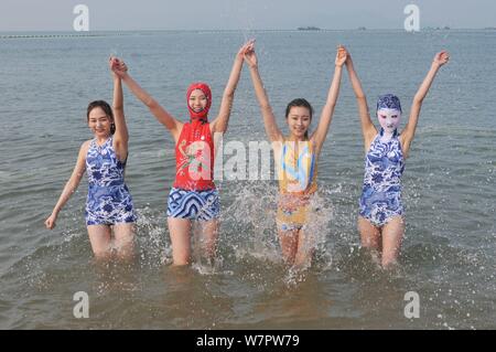 Ein Modell, Rechts, das Tragen eines facekini Badeanzug mit blau-weißen Porzellan und Stickerei ist dargestellt in einem Beach Resort in Qingdao Stadt, Osten Kinn Stockfoto