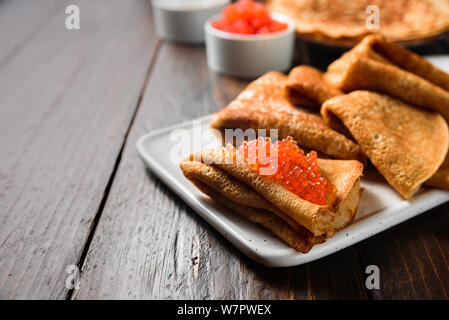 Russische Pfannkuchen Blini mit rotem Kaviar auf hölzernen Hintergrund Stockfoto