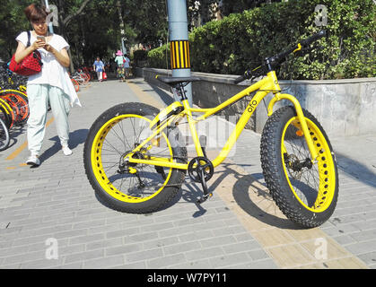 Ein Fußgänger nimmt Fotos eines fatbike mit übergroßen Reifen, auch als Fat oder Fat Tire Bike, der Chinesischen bike-sharing Service ofo in Peking, C Stockfoto