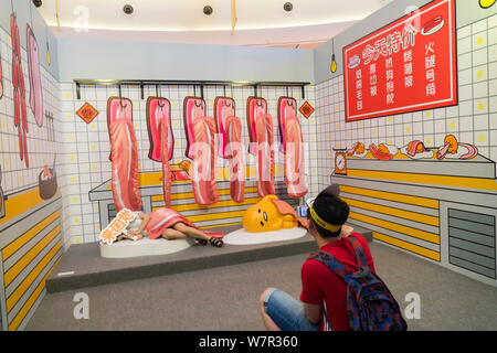 Ein cartoon Enthusiast nimmt ein Foto mit Gudetama, oder faul Ei, von Hello Kitty's Entwickler Sanrio, in Shanghai, China, 19. Juni 2017 erstellt. Die Japa Stockfoto