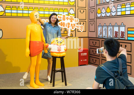 Ein cartoon Enthusiast nimmt ein Foto mit Gudetama, oder faul Ei, von Hello Kitty's Entwickler Sanrio, in Shanghai, China, 19. Juni 2017 erstellt. Die Japa Stockfoto