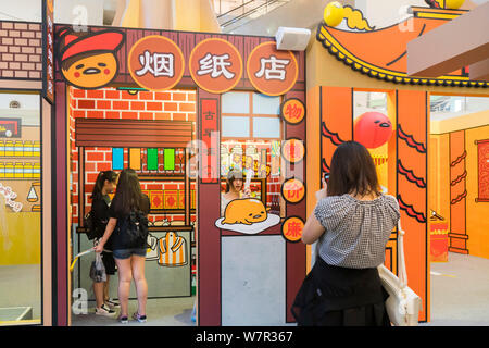 Ein cartoon Enthusiast nimmt ein Foto mit Gudetama, oder faul Ei, von Hello Kitty's Entwickler Sanrio, in Shanghai, China, 19. Juni 2017 erstellt. Die Japa Stockfoto