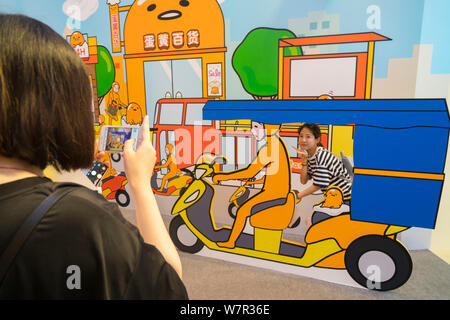 Ein cartoon Enthusiast nimmt ein Foto mit Gudetama, oder faul Ei, von Hello Kitty's Entwickler Sanrio, in Shanghai, China, 19. Juni 2017 erstellt. Die Japa Stockfoto