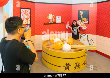 Ein cartoon Enthusiast nimmt ein Foto mit Gudetama, oder faul Ei, von Hello Kitty's Entwickler Sanrio, in Shanghai, China, 19. Juni 2017 erstellt. Die Japa Stockfoto