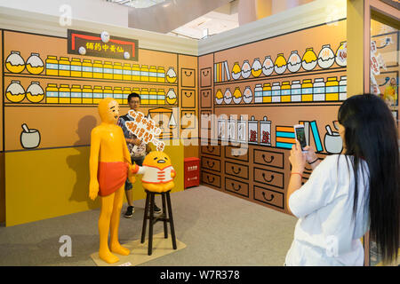 Ein cartoon Enthusiast nimmt ein Foto mit Gudetama, oder faul Ei, von Hello Kitty's Entwickler Sanrio, in Shanghai, China, 19. Juni 2017 erstellt. Die Japa Stockfoto