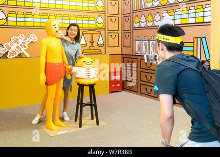 Ein cartoon Enthusiast nimmt ein Foto mit Gudetama, oder faul Ei, von Hello Kitty's Entwickler Sanrio, in Shanghai, China, 19. Juni 2017 erstellt. Die Japa Stockfoto