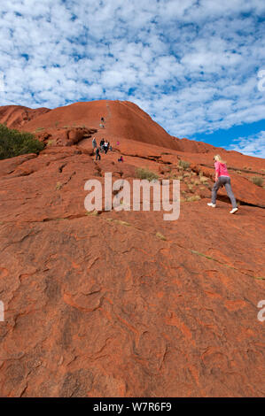 Touristen zu Fuß bis Uluru/Ayers Rock, Uluru Kata Tjuta National Park, Northern Territory, Australien Stockfoto