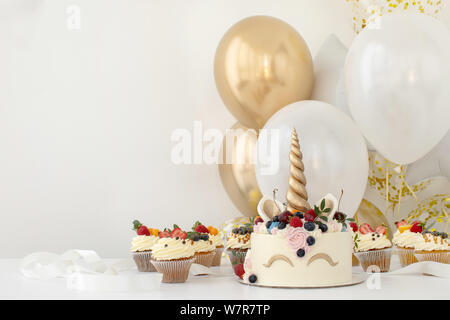 In der Nähe des kleines Mädchen Geburtstag Tabelle mit Unicorn Kuchen Stockfoto