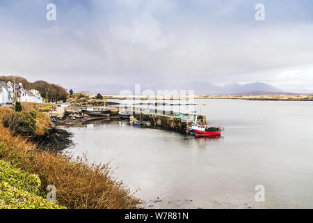 Blick auf Steinbach am Hafen, mit Bergen und Regen Wolken im Hintergrund, Connemara, Irland, März 2013. Stockfoto