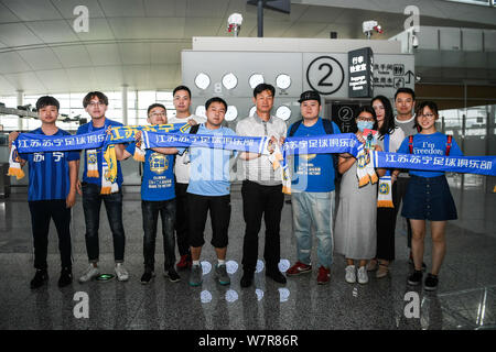 Ehemaliger Haupttrainer Choi Yong-soo von Jiangsu Suning, Mitte, wirft mit Fans vor der Rückkehr nach Südkorea an der Nanjing Lukou Flughafen Stockfoto