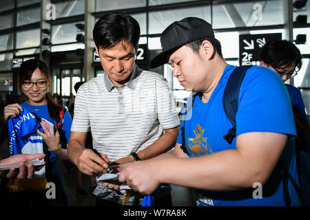 Ehemaliger Haupttrainer Choi Yong-soo von Jiangsu Suning, Mitte, Zeichen ein Autogramm für einen Fan vor der Rückkehr nach Südkorea an der Nanjing Lukou Internati Stockfoto